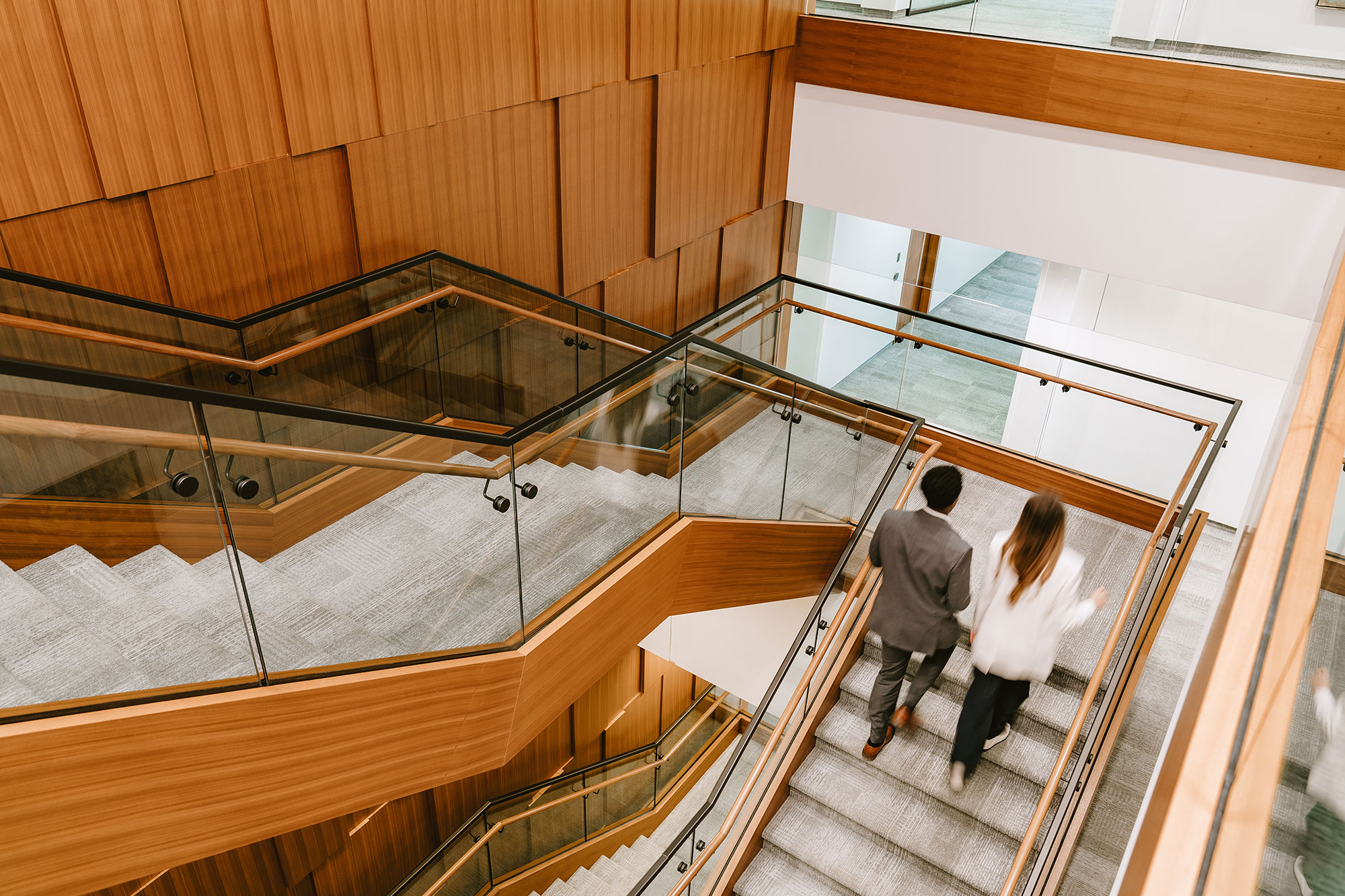 Two lawyers climb a staircase in Osler's office.